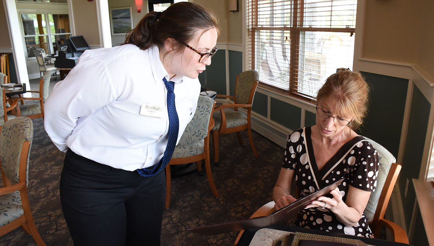 a resident ordering food from her server at her retirement residence